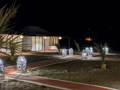 a group of lights in front of a building at night at Glamping Dunes Merzouga in Merzouga