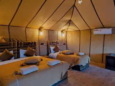 a bedroom with two beds in a tent at Glamping Dunes Merzouga in Merzouga