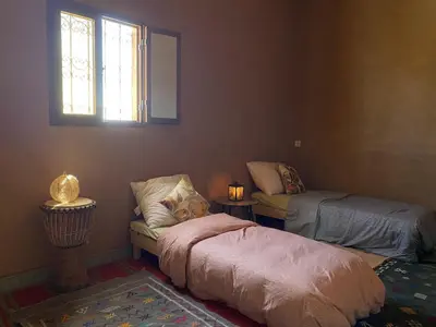 a room with two beds and a couch and a window at Dar Mustapha&Linda GmbH desert-inspiration in Ksebt Ibourri