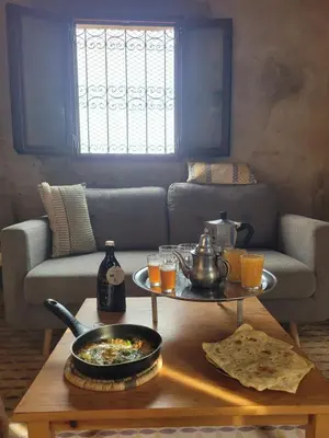a living room with a couch and a table with food on it at Dar Mustapha&Linda GmbH desert-inspiration in Ksebt Ibourri