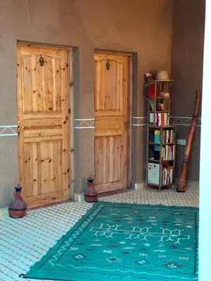 a room with two wooden doors and a rug at Dar Mustapha&Linda GmbH desert-inspiration in Ksebt Ibourri