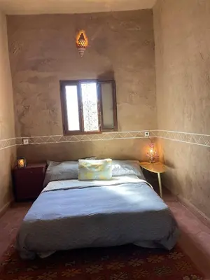 a bedroom with a large bed with a window at Dar Mustapha&Linda GmbH desert-inspiration in Ksebt Ibourri