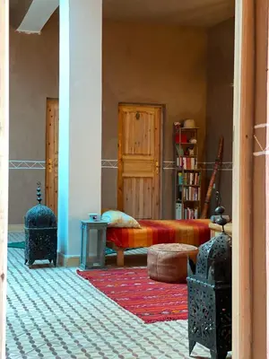 a living room with a bed and a rug at Dar Mustapha&Linda GmbH desert-inspiration in Ksebt Ibourri