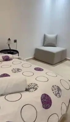 a bedroom with a bed and a rug on the floor at Appartement de luxe à khouribga in Khouribga