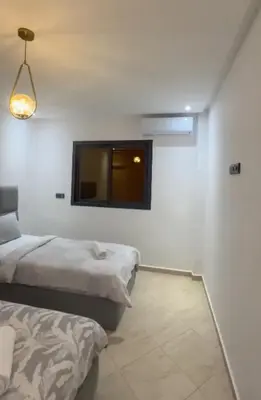 a room with two beds and a tv on the wall at Appartement de luxe à khouribga in Khouribga