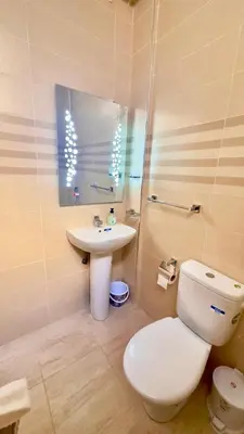 a bathroom with a white toilet and a sink at Appartement de luxe à khouribga in Khouribga