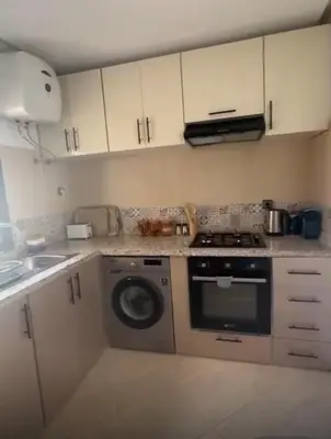 a kitchen with a stove and a washing machine at Appartement de luxe à khouribga in Khouribga
