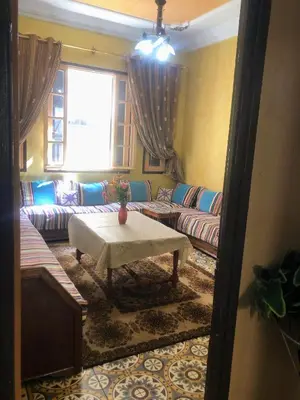 a living room with a couch and a table at Tisra Appartement in Meknès