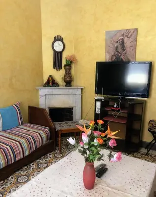 a living room with a television and a vase with flowers at Tisra Appartement in Meknès