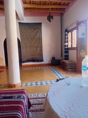 a room with a table and a wall with a window at Hotel Source De Dades in Boumalne