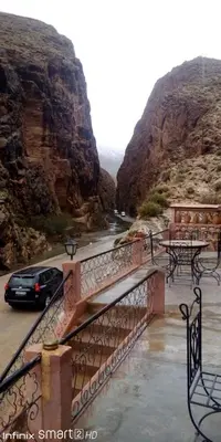 a car driving on a bridge over a canyon at Hotel Source De Dades in Boumalne