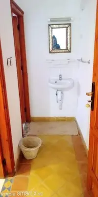 a white bathroom with a sink and a mirror at Hotel Source De Dades in Boumalne
