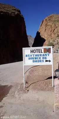 a hotel sign in the middle of the desert at Hotel Source De Dades in Boumalne