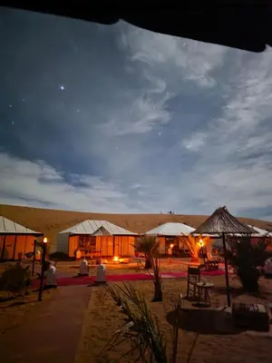 a building in the middle of a desert at night at Amrad luxury camp in Merzouga