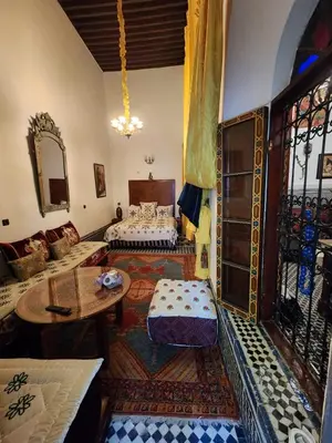 a living room with a bed and a table at Dar Zerbtana suite Kenza in Fès