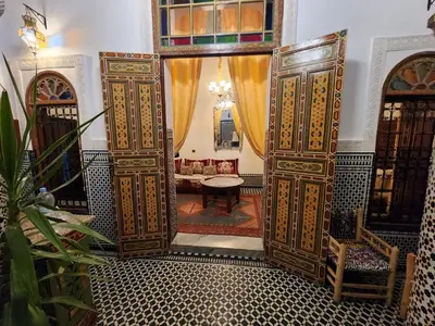 an entrance to a room with wooden doors at Dar Zerbtana suite Kenza in Fès