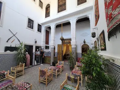 a courtyard of a building with people standing in it at Dar Zerbtana suite Kenza in Fès