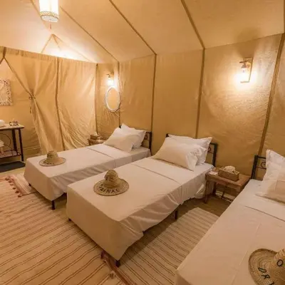 a room with two beds in a tent at Merzouga Experience Camp in Merzouga