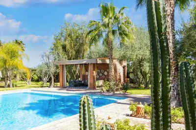 a house with a swimming pool and cactus at Villa Layyine avec personnel, piscine, spa et sports in Marrakech