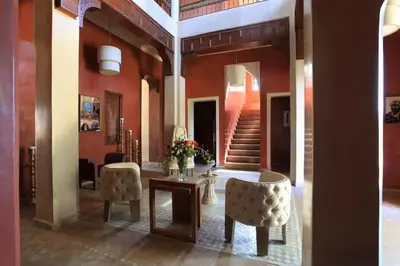 a room with a table and two chairs and a staircase at Villa Layyine avec personnel, piscine, spa et sports in Marrakech