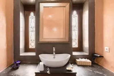 a bathroom with a large white sink and two windows at Villa Layyine avec personnel, piscine, spa et sports in Marrakech