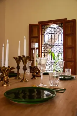 a wooden table with a green plate on top of it at Villa Dar Al Hayat in Marrakech