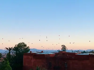a group of kites flying in the sky at sunset at Villa Dar Al Hayat in Marrakech