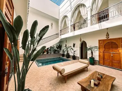 a living room with a pool and a couch and a table at Villa Dar Al Hayat in Marrakech