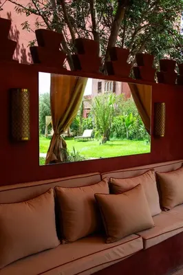 a couch with pillows in a room with a window at Villa Dar Al Hayat in Marrakech