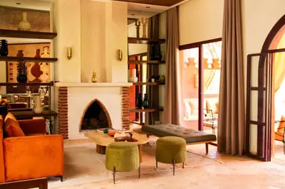 a living room with a fireplace and a table and chairs at Villa Dar Al Hayat in Marrakech