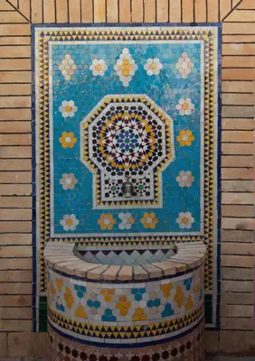 a colorful rug on a wall next to a barrel at Dar Bab jdid fez in Fès