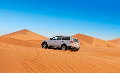 a truck in the sand in the desert at Desert Tigmi Camp in Merzouga