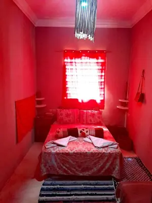 a red bedroom with a bed and a window at Dar INNÂ in Aït Ben Haddou