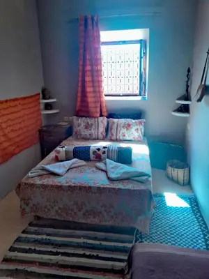a bedroom with two beds and a window at Dar INNÂ in Aït Ben Haddou