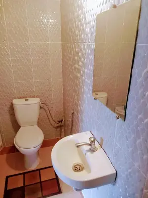 a bathroom with a toilet and a sink and a mirror at Dar INNÂ in Aït Ben Haddou