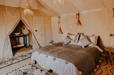 a bedroom with a large bed in a tent at Soul Dunes Luxury Camp in Merzouga