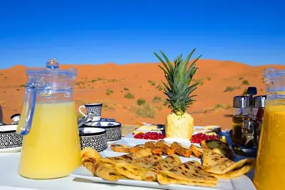 a table with a plate of food in the desert at Soul Dunes Luxury Camp in Merzouga