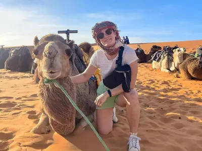 a young girl riding a camel in the desert at Soul Dunes Luxury Camp in Merzouga