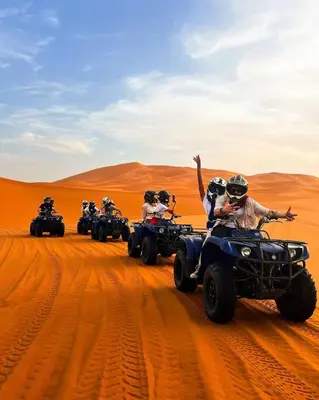 a group of people riding atvs in the desert at Soul Dunes Luxury Camp in Merzouga