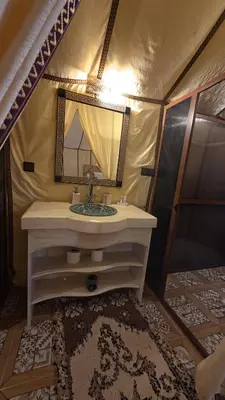 a bathroom with a sink and a mirror in a tent at Merzouga Safari Luxury Camp in Tisserdmine