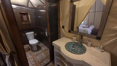 a bathroom with a sink and a mirror and a toilet at Merzouga Safari Luxury Camp in Tisserdmine