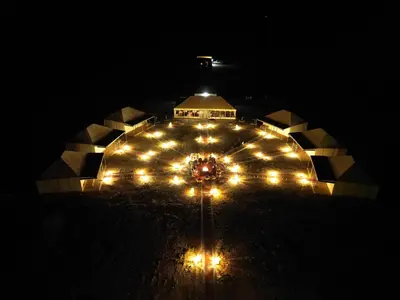 a large building with lights on it at night at Merzouga Safari Luxury Camp in Tisserdmine
