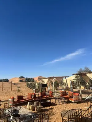 a group of chairs and tables in the desert at Desert Nomads Camp in Merzouga