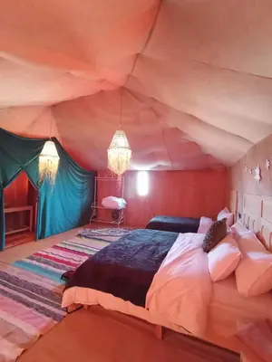 a bedroom with a large bed in a tent at Desert Nomads Camp in Merzouga