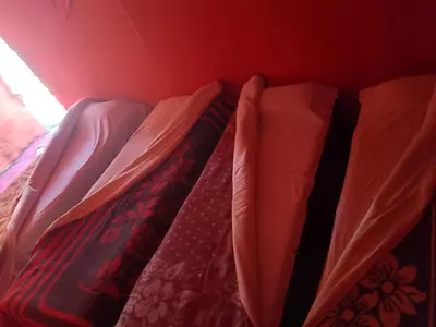a bed in a room with two sheets at Merzouga your Tour Nigths in Camp in Merzouga