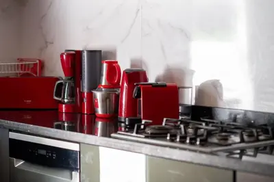 a kitchen counter with a stove with a red appliance at Villa Lumina in Marrakech