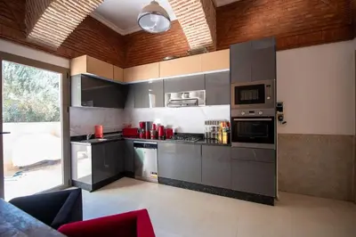 a kitchen with gray cabinets and a large window at Villa Lumina in Marrakech