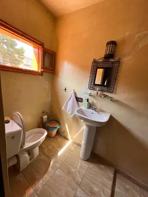 a bathroom with a sink and a toilet and a window at Maison d´hôtes Amazir in Ouzoud