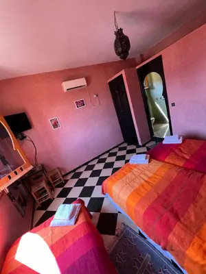 a room with two beds and a checkered floor at Maison d´hôtes Amazir in Ouzoud