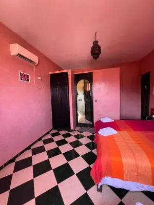 a bedroom with a colorful bed and a checkered floor at Maison d´hôtes Amazir in Ouzoud